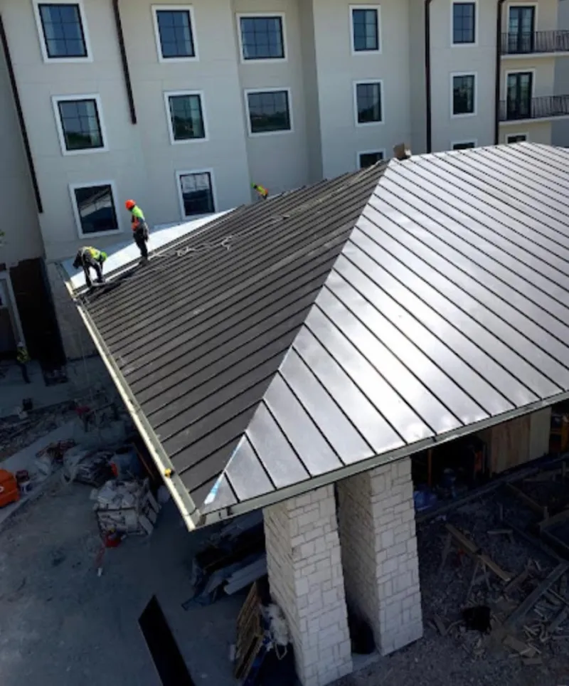 Crew installing standing seam metal roof panels on a commercial project in La Palma